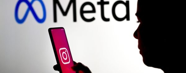 March 16, 2022, Brazil. In this photo illustration, a woman holds a smartphone with the Instagram logo displayed on the screen with the Meta Platforms logo displayed in the background
